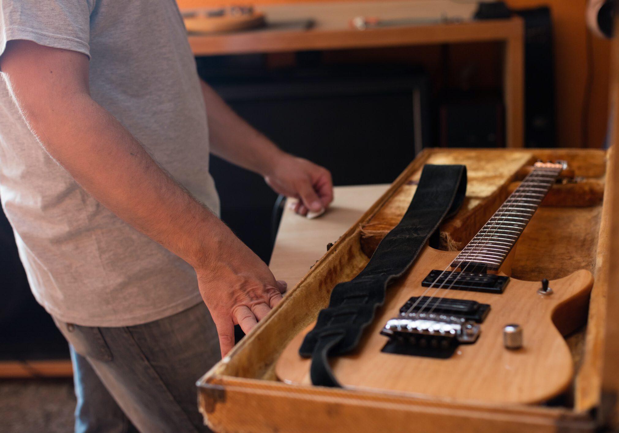 Person standing by open guitar case.